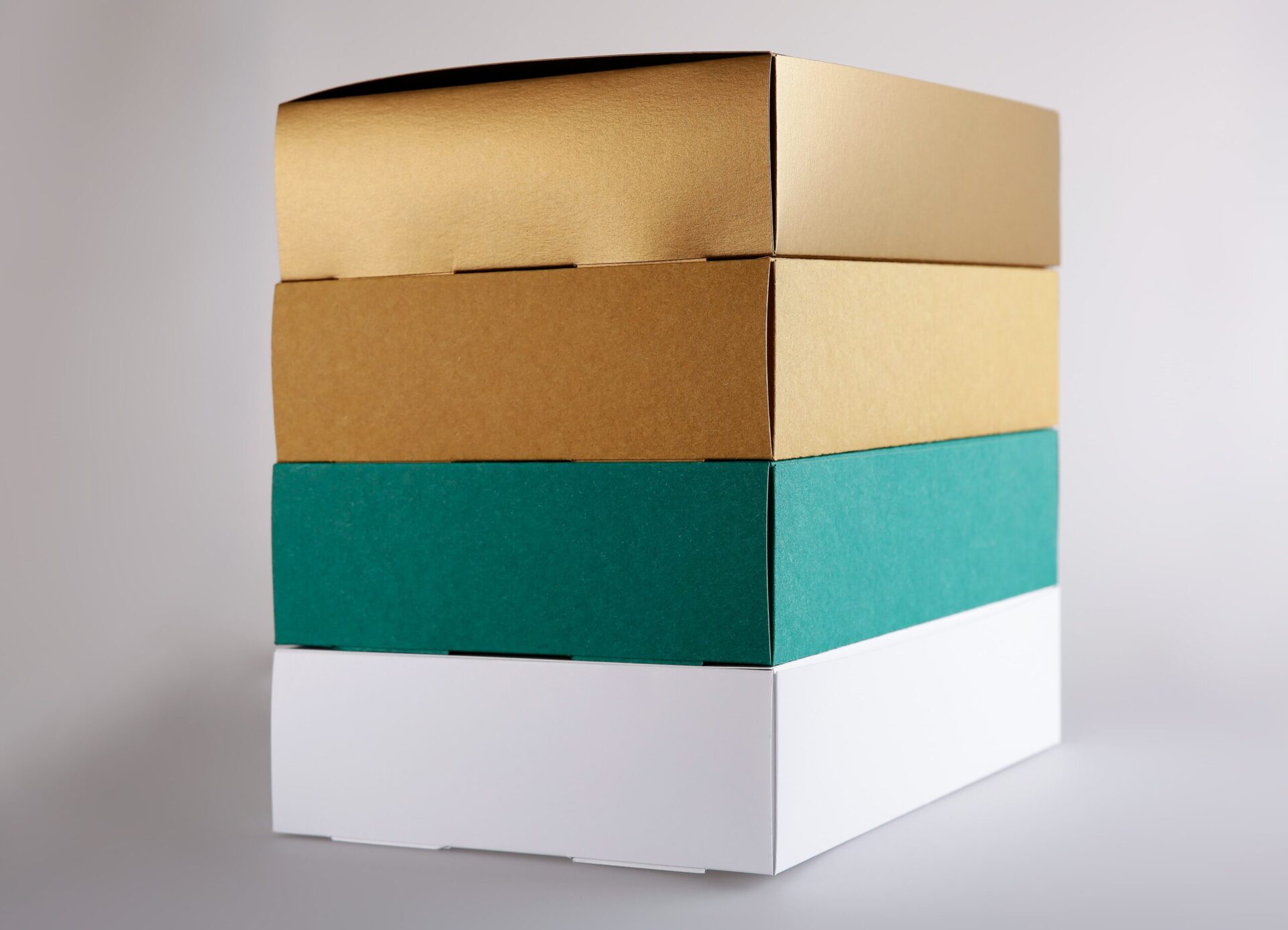 Stapel Verpackungen bedruckt Gold, Grün und Weiss