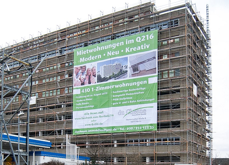 XXL-Banner mit Werbedruck an einem eingerüsteten Wohngebäude für Mietwohnungen im Q216 in Berlin.