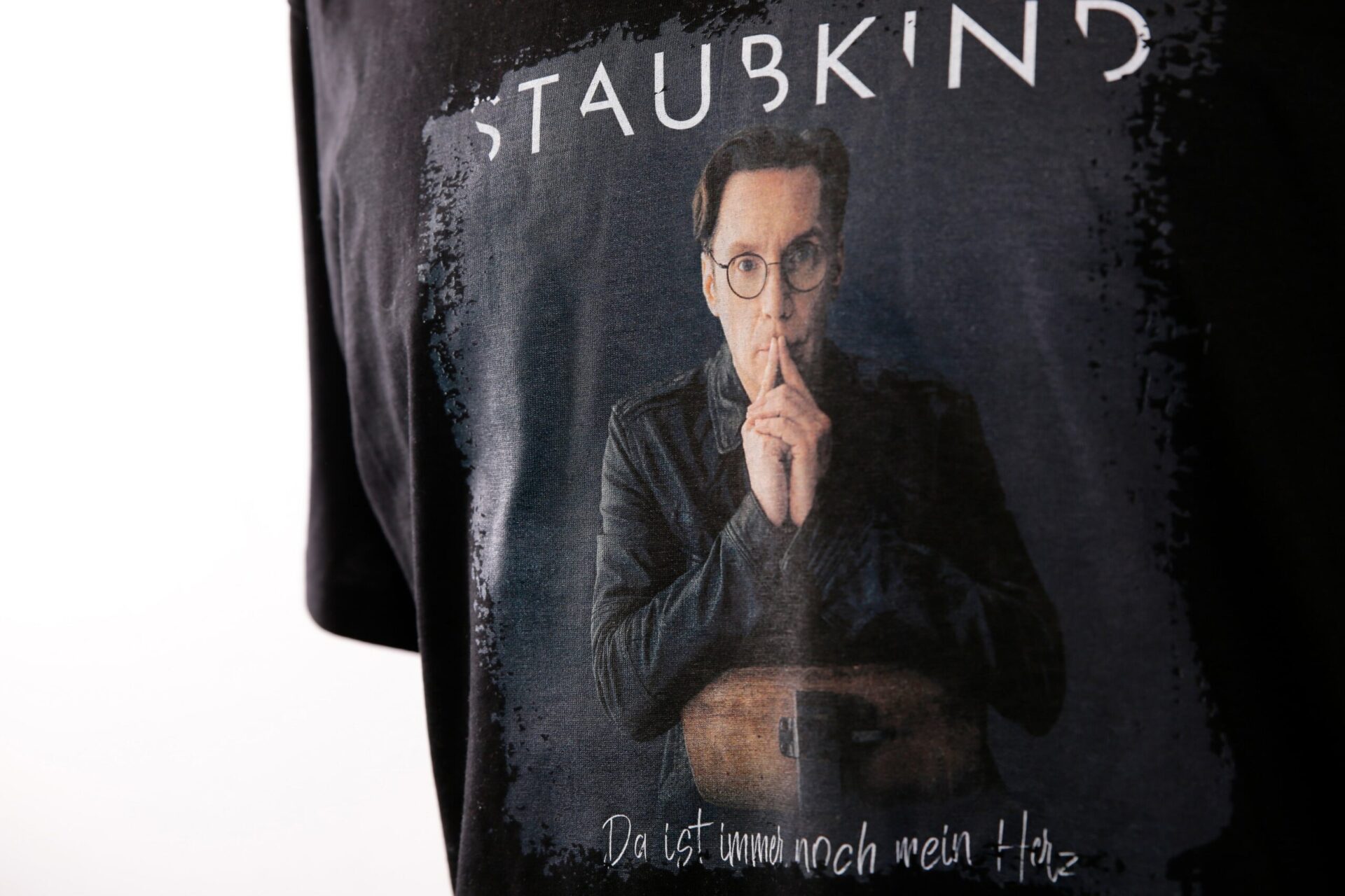 Detailansicht eines Transferdrucks von Staubkind auf schwarzem T-Shirt