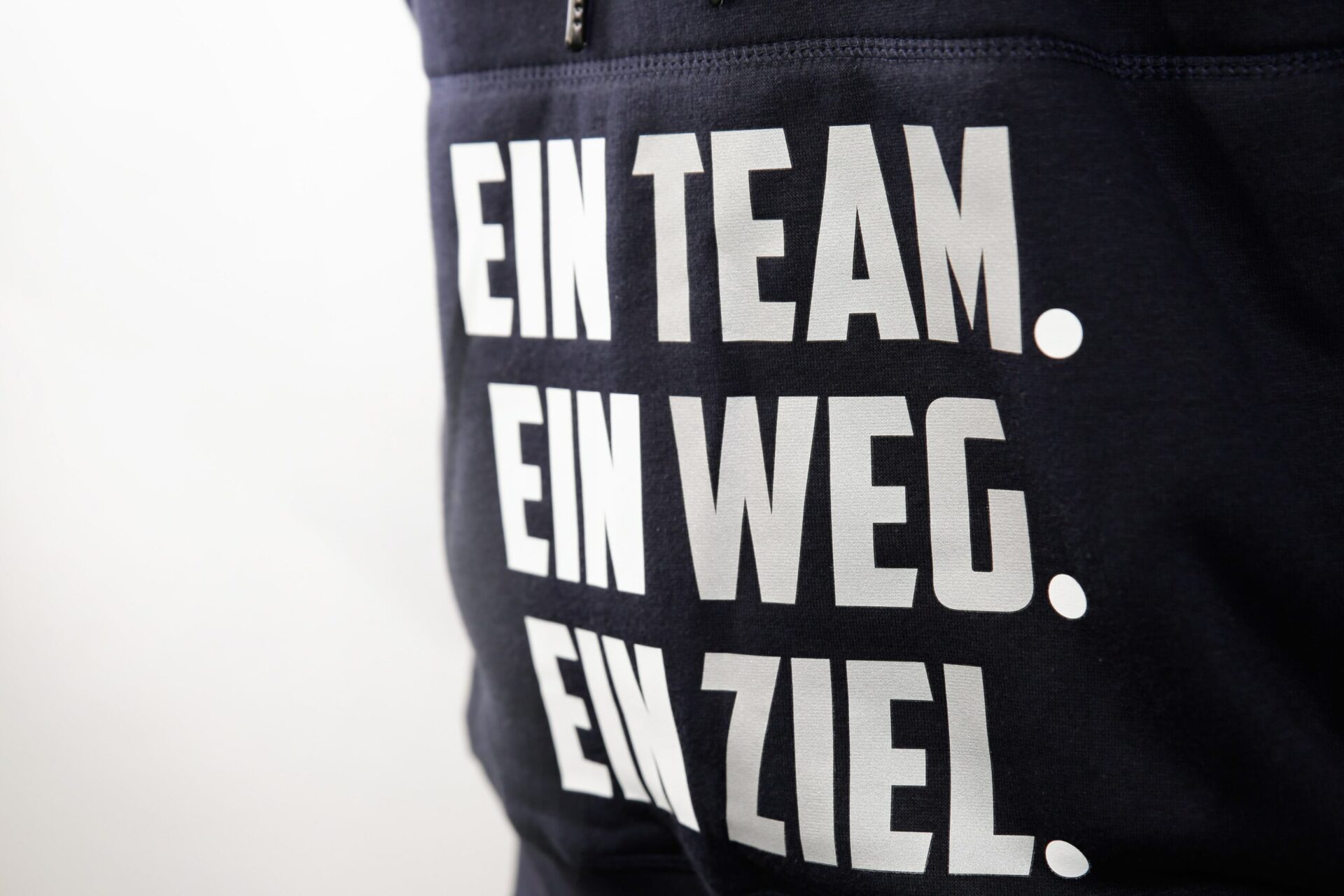 Detailansicht von einem weißen Transferdruck auf dunkelblauem Pullover