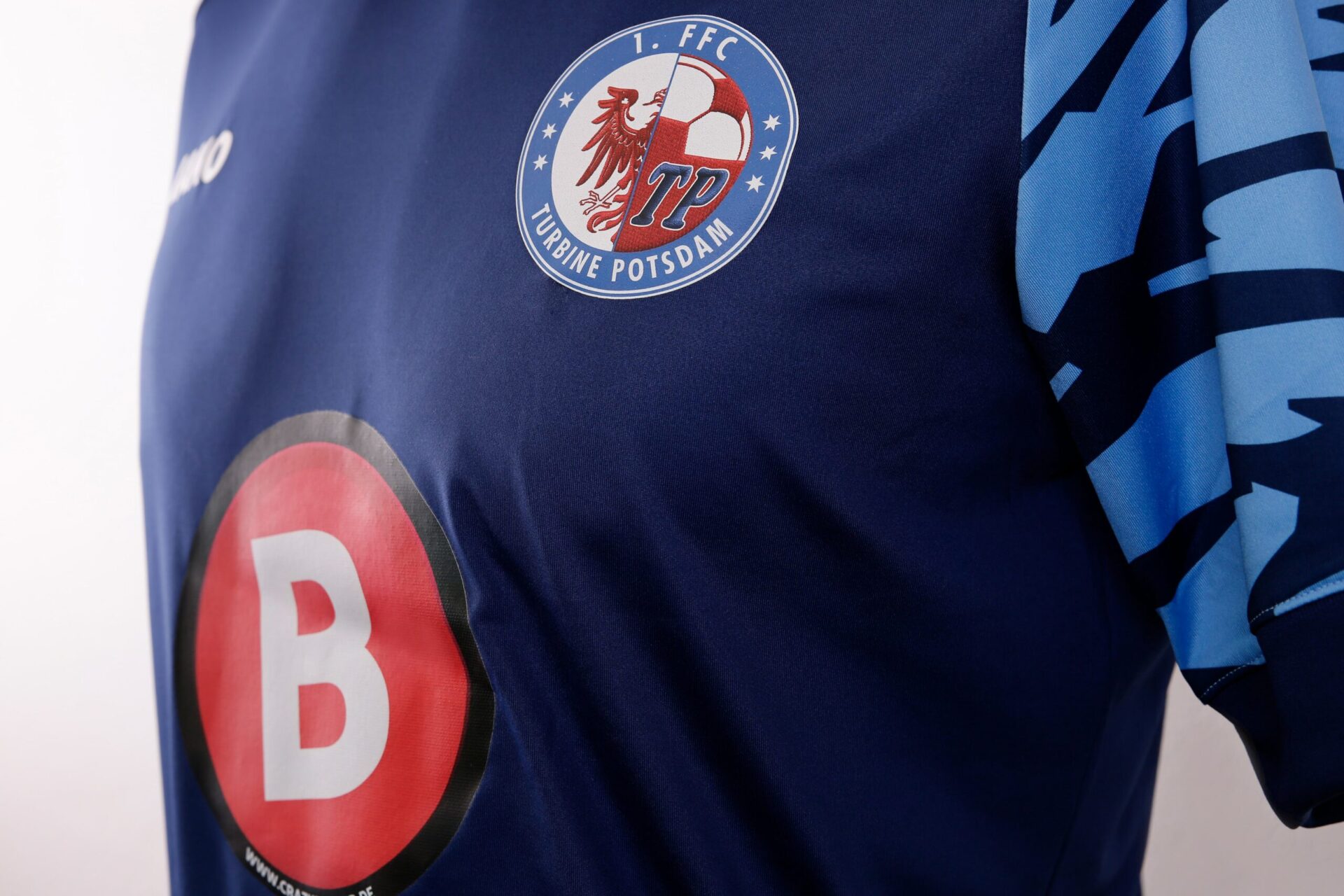 Detailansicht von blauem Trikot mit zwei Logo Transferdrucks