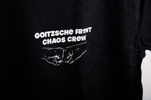 Detailansicht von einem weißen Logodruck auf schwarzem T-Shirt