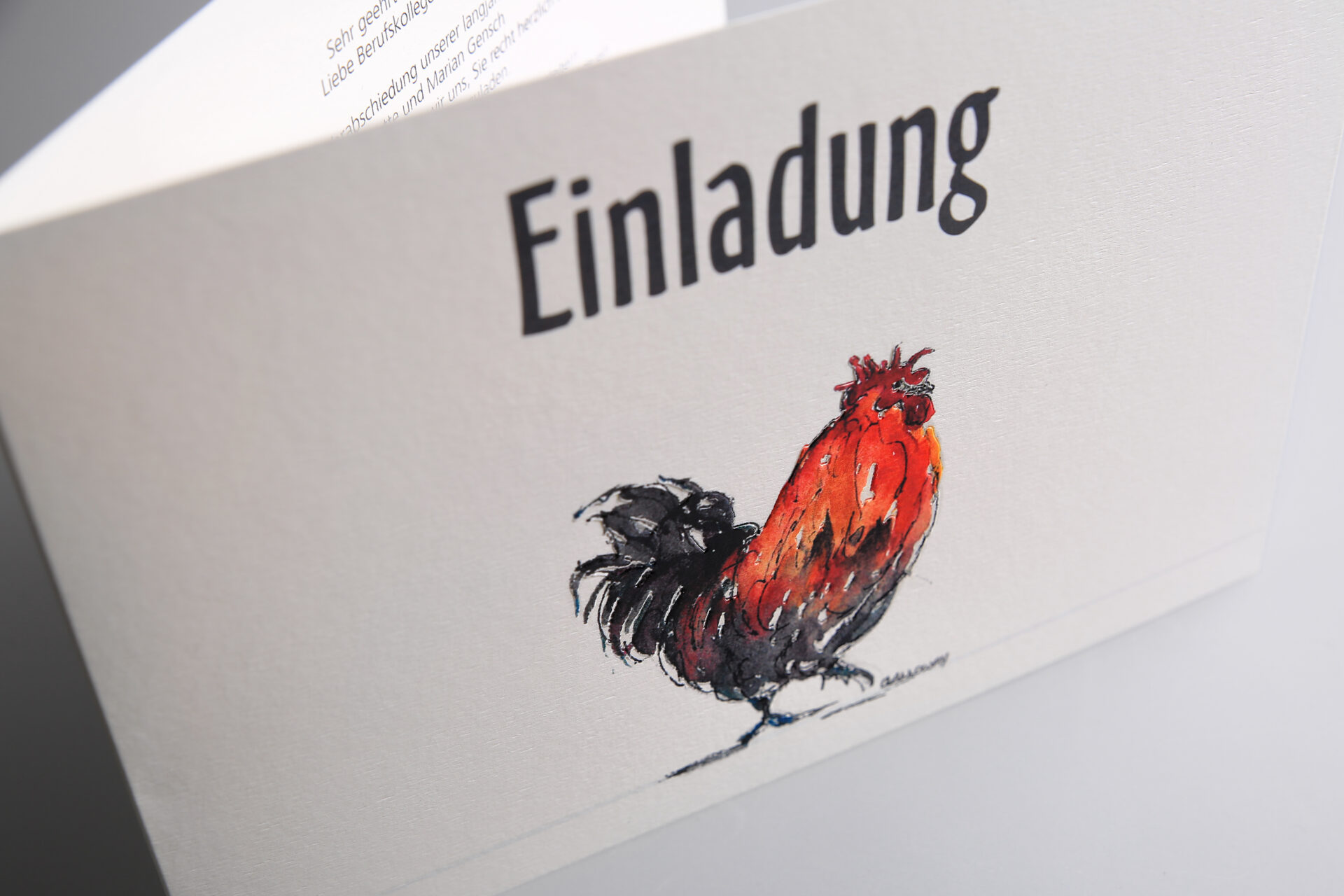 Einladungskarte mit Blindprägung eines Hahns