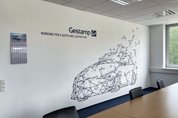 Wandgestaltung mit Firmenlogo und geometrischem Autodesign bei Gestamp im Konferenzraum