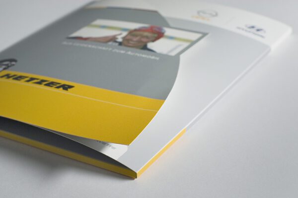 Professionell gestaltete Präsentationsmappe mit modernen grafischen Elementen und Firmenbranding.