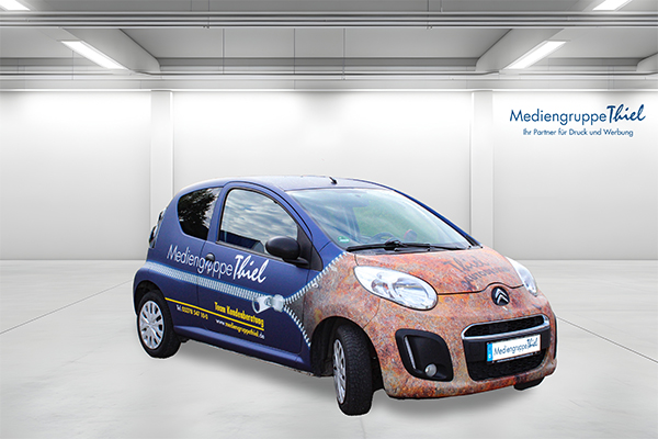 Citroën C1 mit kreativer Vollfolierung: Rostoptik auf der Front und tiefblaues Branding der Mediengruppe Thiel auf den Seiten.