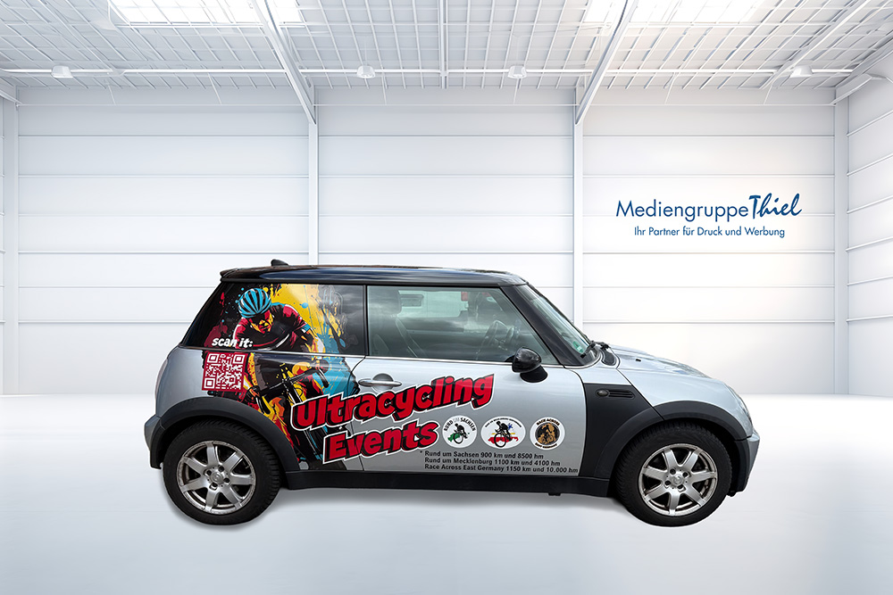 Professionelle Fahrzeugbeschriftung für Ultracycling Events Vollansicht eines beschrifteten Fahrzeugs mit sportlichem Design, QR-Code und Logos – realisiert von der Mediengruppe Thiel.
