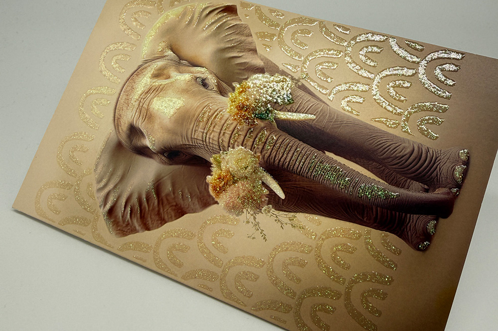 Grußkarte mit Elefant, goldfarbenem Glitzerlack-Muster und floralen Akzenten; funkelnde Details, edler Relief-Effekt.