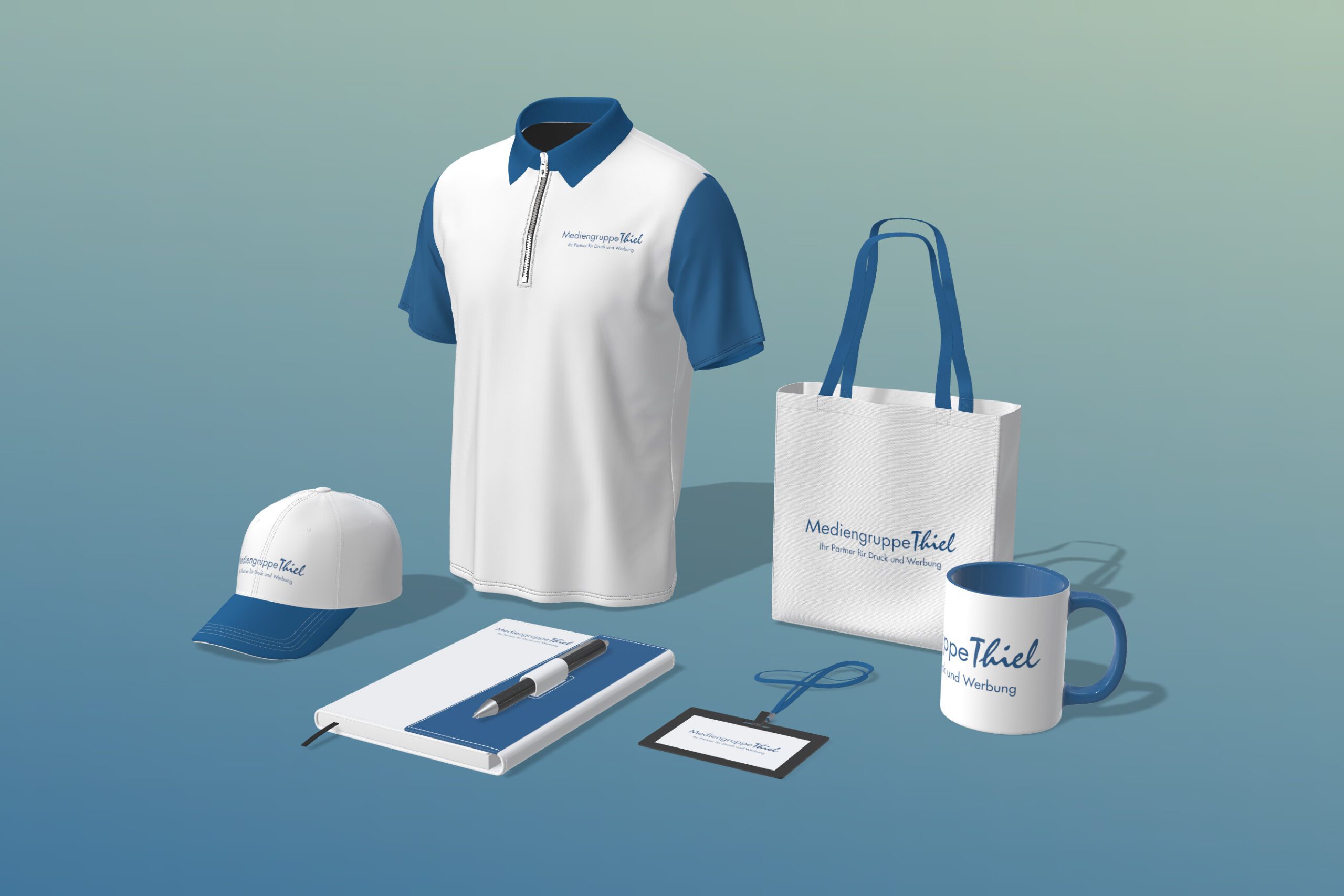 Ein Set von Werbematerialien, einschließlich eines T-Shirts, einer Kappe, einer Tasche, einer Tasse, eines Notizbuchs, eines Stifts und eines Namensschilds, alle mit dem Logo der Mediengruppe Thiel.