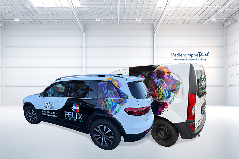 Gebrandeter SUV und Lieferwagen des FELIX Malerbetriebs mit buntem Löwenmotiv in heller Halle der Mediengruppe Thiel.